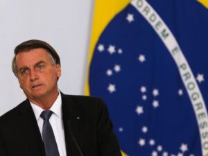 ** Homem segurando um botijão de gás, simbolizando auxílio gás do governo.