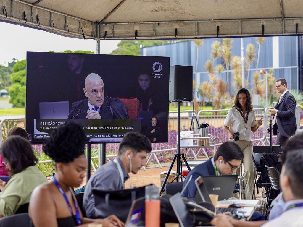 Advogados discutindo estratégias para defesa de réus do golpe.