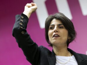Manuela D'Ávila durante evento do PSOL, destaque na esquerda.