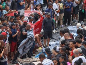 ** Policiais da operação no Rio com corpos expostos em praça.