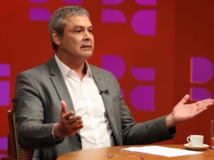 Lindbergh Farias e Hugo Motta em debate no Congresso, refletindo tensões e crises.