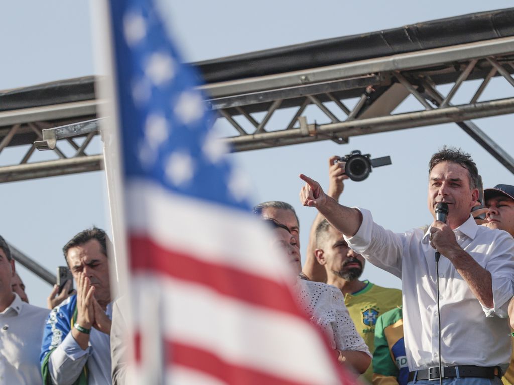 ** Flávio Bolsonaro em encontro político, busca apoio financeiro.